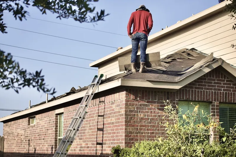 Professional roofer working on a residential roof in Worthville